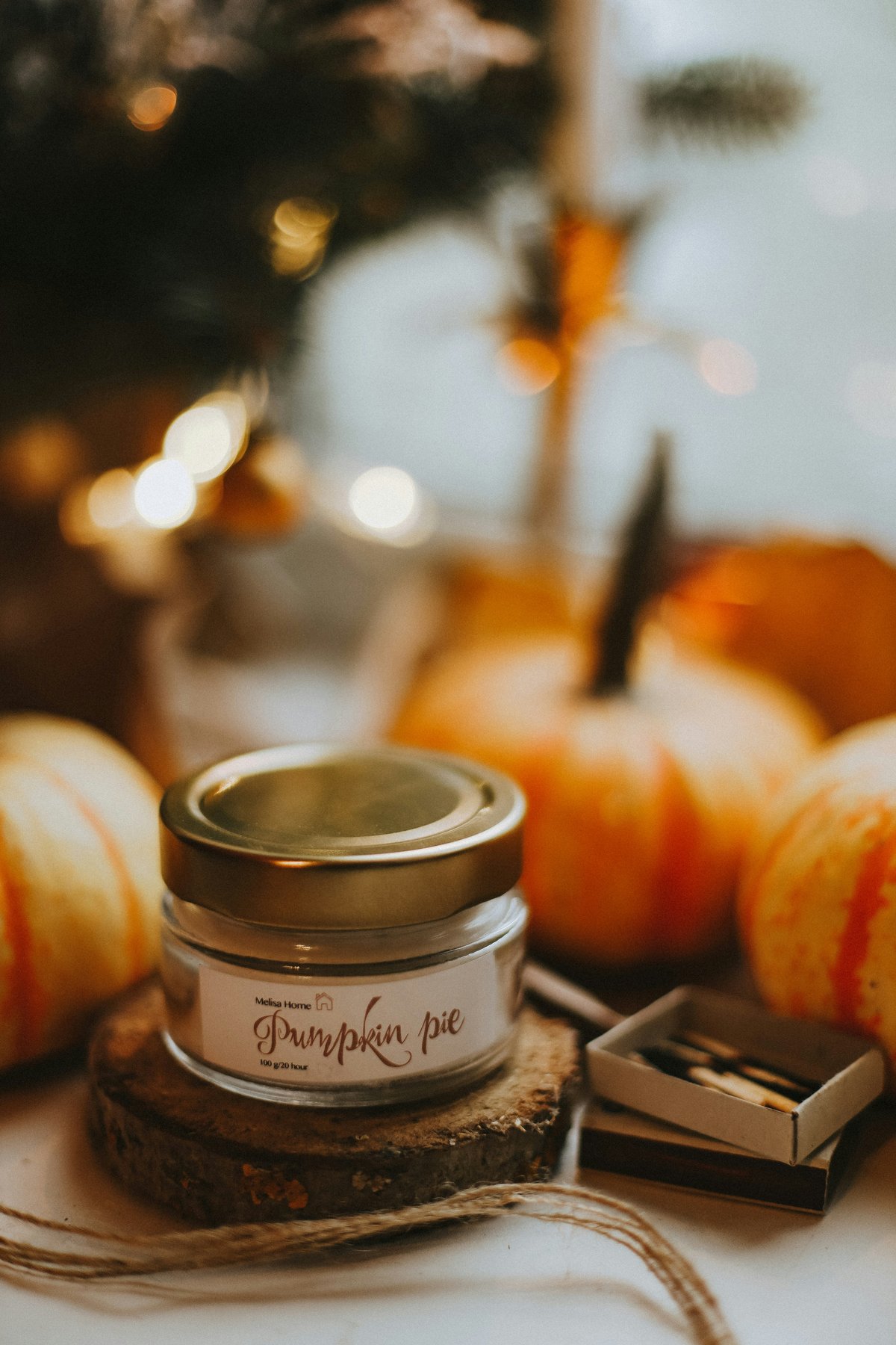 A jar of pumpkin pie spice among small pumpkins