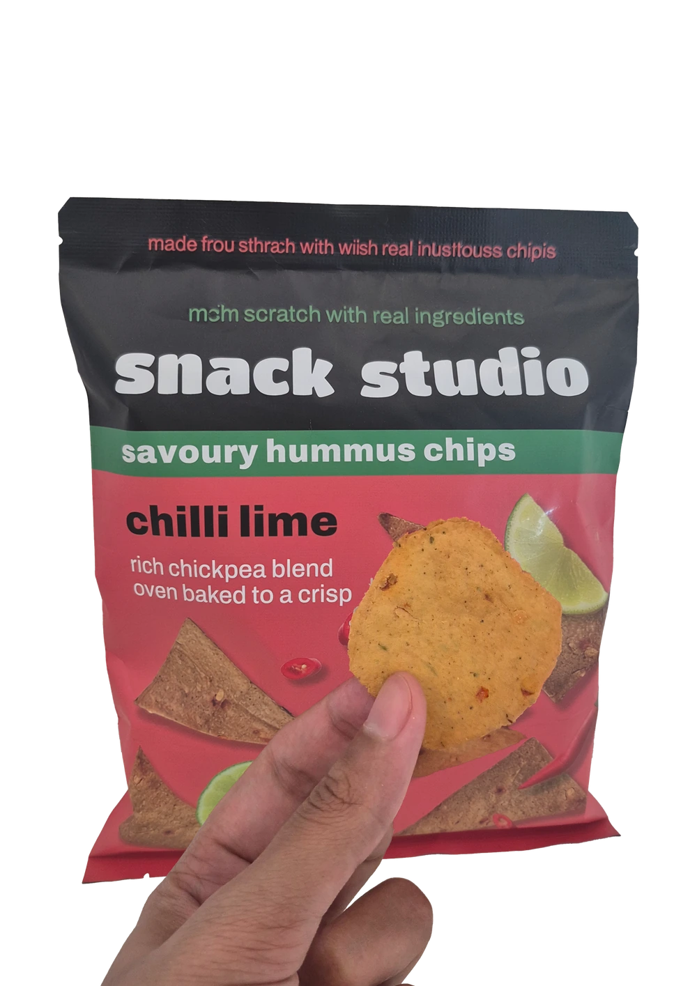 Holding up a Snack Studio chilli lime hummus chip in front of the packet