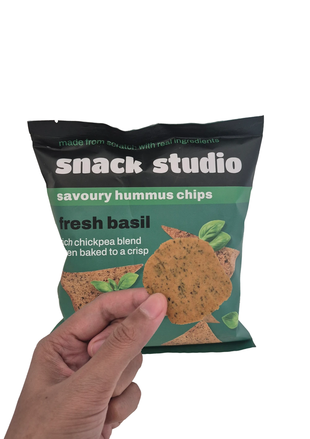 Holding up a Snack Studio fresh basil hummus chip in front of the packet